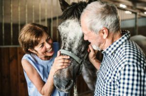 The Craig | Happy seniors petting a horse