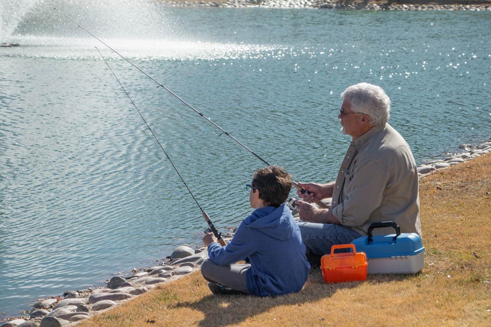 Senior man fishing with his grandchild